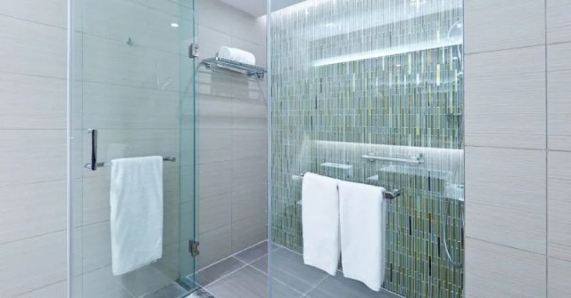 Framed glass shower door with metal handle and hardware